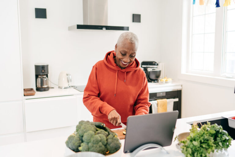 Senior women cooking and using tablet on the kitchen